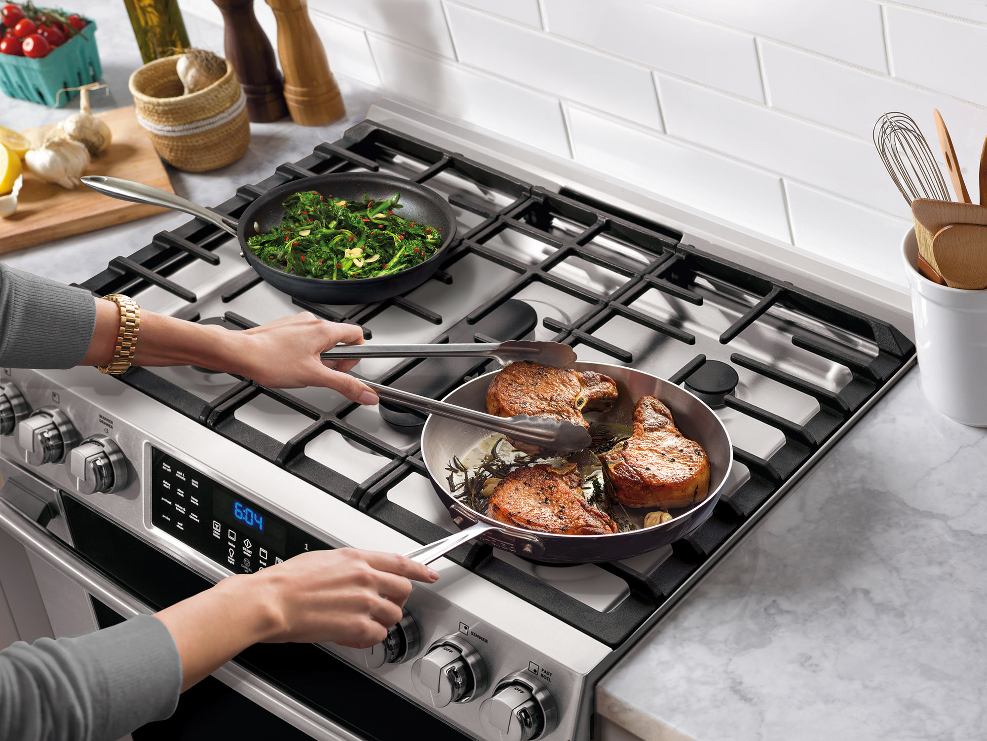 Gas cooktop in use with pans on continuous grates
