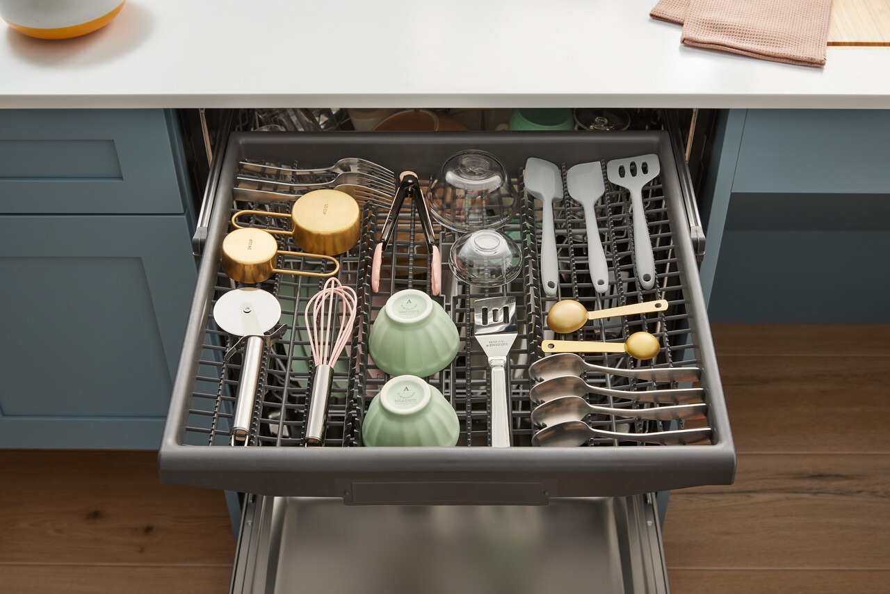 Third rack loaded with utensils and small items inside the dishwasher