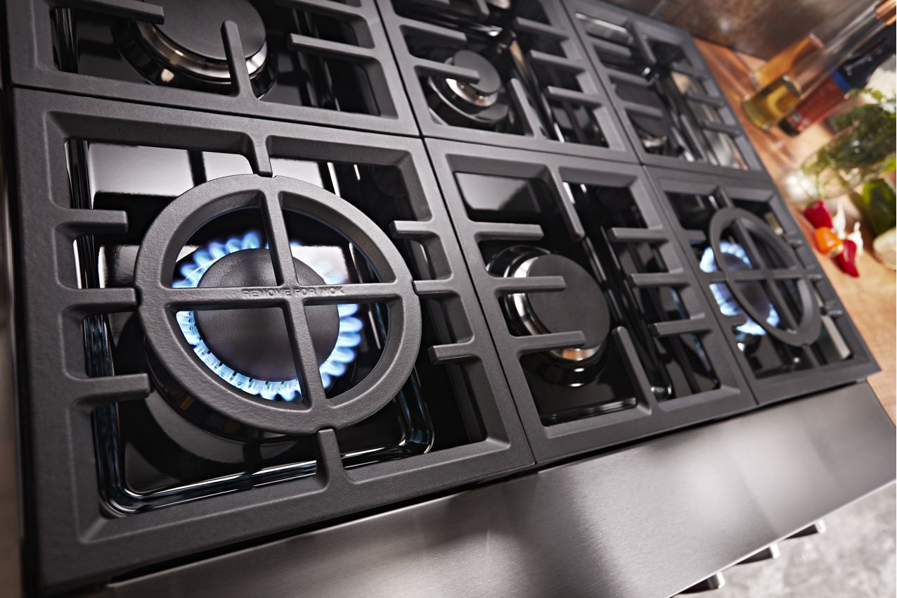 Close-up of gas burner flames under heavy cast-iron grates